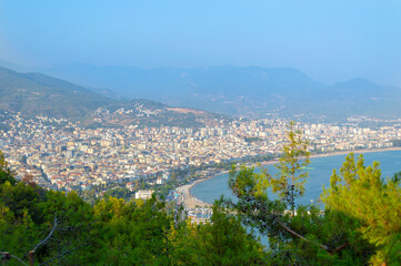 Fototapeta na wymiar View to the sea coast line of Alanya city, Turkey, resort area in summer time under the blue sky, blue waters