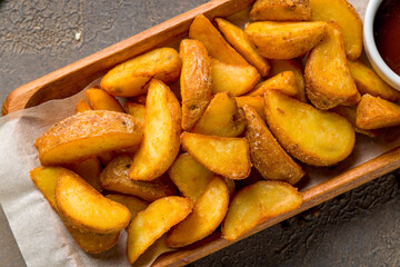 The potatoes wedges on the Board on brown table top view macro close up