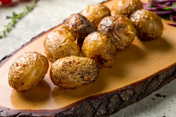 baked mini potatoes on the board on stone table macro close up