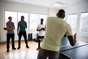 Rear view of coach conducting training sessions with students in games room