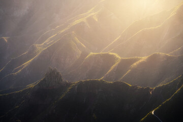 Amazing sunset over volcanic cliffs with a big orange light on an island