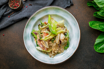 Salad with seafood on bowl on brown table top view
