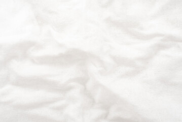 A twisted piece of white fabric. White material or texture with waves and folds. Wrinkled white fabric