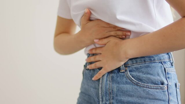 Woman suffering from stomach ache. Holding belly and feeling abdominal menstrual pain or bowel and digestion problems