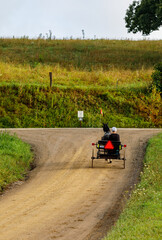Amish woman riding a horse and cart on a back road in Holmes County, Ohio