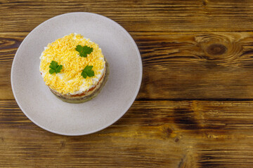 Traditional russian salad Mimosa on wooden table. Top view