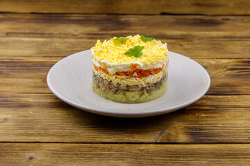 Traditional russian salad Mimosa on wooden table