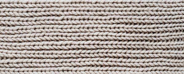 Knitting. Vertical striped beige knit fabric texture, knitted pattern background. Top view, banner