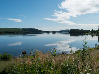 summer view of Lille Lulealven river at Jokkmokk, blue sky white clouds