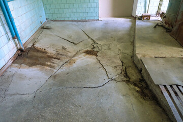 Fototapeta na wymiar Destroyed concrete flooring due to subsidence of the base soil