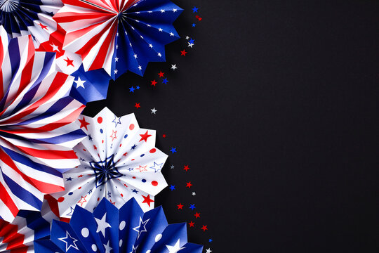American Independence Day paper fans and red white blue confetti on black table. USA Independence Day or Labor day celebration concept.