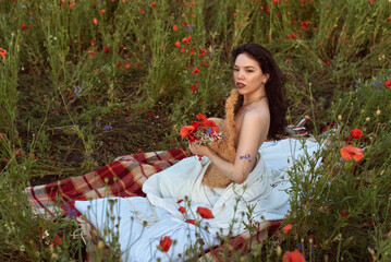 A young girl in a flowering poppy field