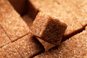 Brown sugar cubes macro. One cube lying over another set cubes