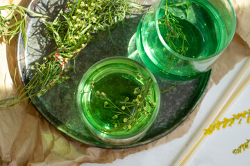Water with tarragon grass on a light background
