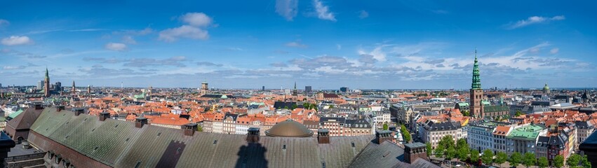 Fototapeta na wymiar Panorama view Copenhagen, Denmark skyline from Christiansborg Palace tower. Aerial view of roofs and cityscape on a sunny day with the towers of the most important sightseeing spots
