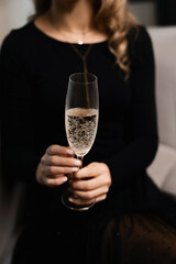 Glass of white sparkling champagne in woman's hands
