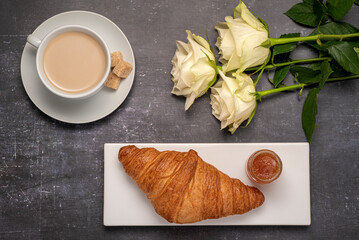 Food photography of breakfast, croissant, cappuccino, jam, rose