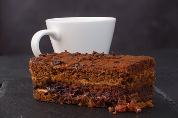 cake and coffee mug on dark stone background