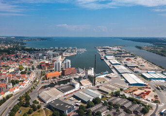Summer cityscape of Horsens, Jutland, Denmark. Aerial panorama of the industrial area around Horsens Havn (harbor) and the Fjord in the background - obrazy, fototapety, plakaty