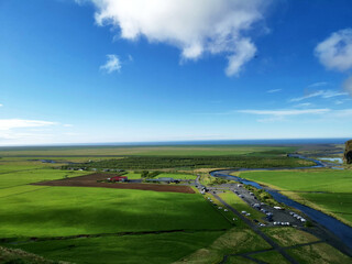 A perfect clear view over green grass fields from stairs up in iceland fields farm