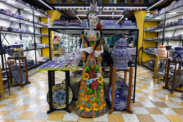 pottery sculpture statue of a traditional catrina mexican skeleton skull in a souvenir store in...