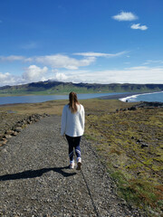 Girlfriend walking shore black beach iceland island with sunshine blue sky roadtrip