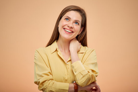 Smiling dreaming woman looking up, isolated portrat on studio yellow background.