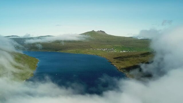 Aerial view of Sorvagsvatn lake or Leitisvatn, Biggest lake in Faroe Islands. Flying through the clouds. Amazing mist and foggy Faroese nature. High quality 4k footage.