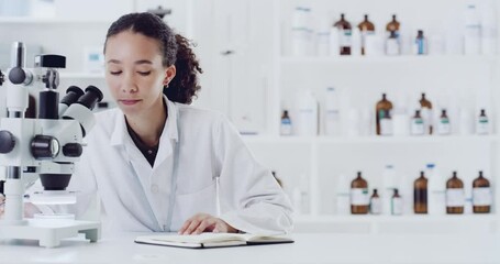 Forensic scientist, microscope and woman writing notes for information on experiment or research in a lab. Female in microbiology science looking in scope for discovery, cure and documenting results.
