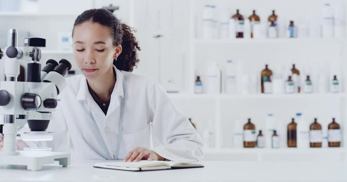 Forensic scientist, microscope and woman writing notes for information on experiment or research in a lab. Female in microbiology science looking in scope for discovery, cure and documenting results.