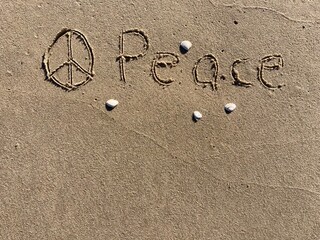 on the beach is carved with letters in the smooth sand the writing Peace