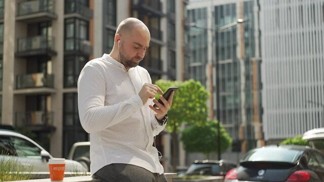 The manager, the man, corresponds on the phone, solves cases. A man with a serious expression on his face in casual clothes checks the stock exchange. High quality 4k footage