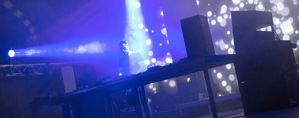 Dj playing techno music on the stage at night summer concert - obrazy, fototapety, plakaty