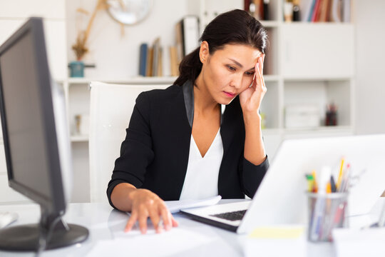 Tired businesswoman working with documents in business office