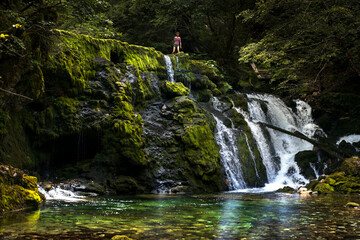 Woman Enjoying Wilderness Discovering with Moss Covered Beautiful Waterfall - Bohinjska Bistrica River Spring, Slovenia