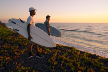 Surfers watching the waves at sunset