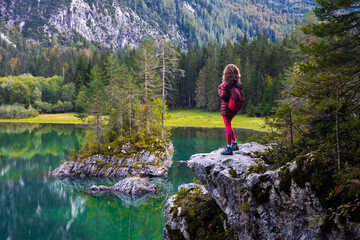 Naklejka na ściany i meble Woman Hiker Standing and Looking At View Of beautiful Alpine Environment of Fusine Upper Lake in Italian Julian Alps