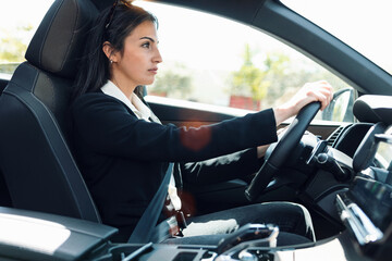 Beautiful businesswoman driving her car in the city.