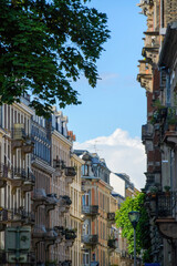Perspective view over French street with tall haussmannian buildings blue sky with cumulus cloud