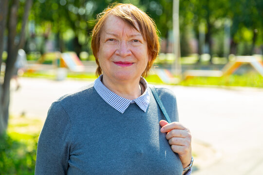 Portrait Of A Smiling Mature Woman Walking Down The Street On A Summer Day. Close-up Portrait