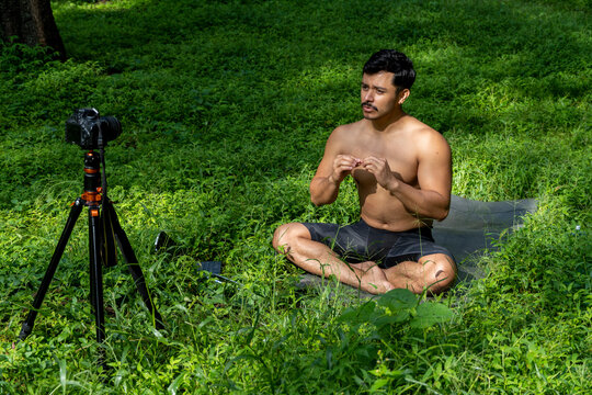 View of a man conducting virtual fitness class with group of people at home on a video conference. Fitness instructor taking online yoga classes