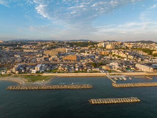 Aerial view of tetrapod concrete breakwaters protecting condos in small coastal town - 527477987
