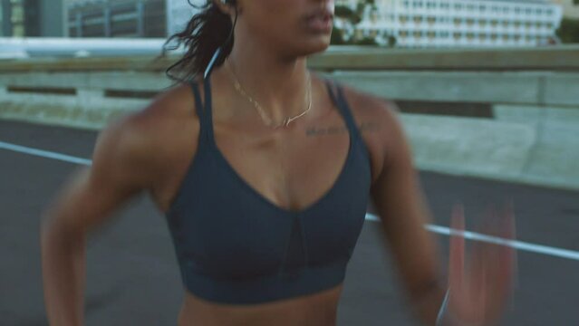 Motivation, music and running with fitness woman training run for health, wellness and exercise in urban street or road. Sport, workout and energy girl runner working out for event, race or marathon