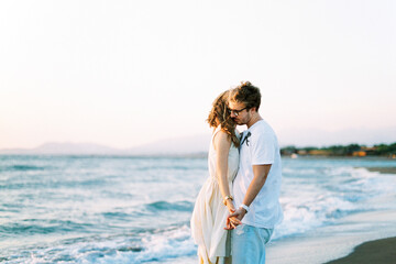 Fototapeta na wymiar Man and woman hugging holding hands on the beach