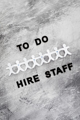 To Do Hire Staff text with paper people chain and question marks on vacant positions to fill, staff...