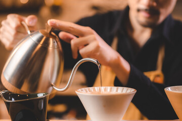 hipster barista pouring a hot water to making coffee with drip or filter style in cafe, slow brew for caffeine aroma beverage drink in cup, fresh black coffee and espresso for breakfast