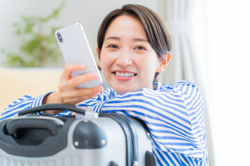 携帯を持ち笑顔の日本人女性