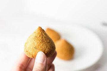 woman ready to eat a delicious coxinha - brazilian food, chicken croquette
