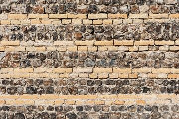 Mur en pierres et rang&eacute;es de briquettes beiges