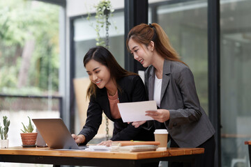 Two Asian Beautiful Business woman working and analysis financial budget of company